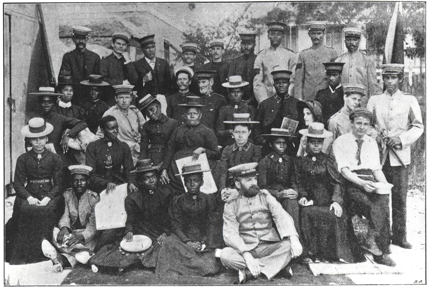 A large group of men and women in Salvation Army uniforms pose for a photograph