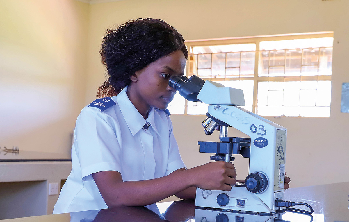 A woman in Salvation Army uniform looks through a microscope