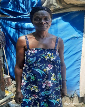 A woman stands in a camp for displaced people