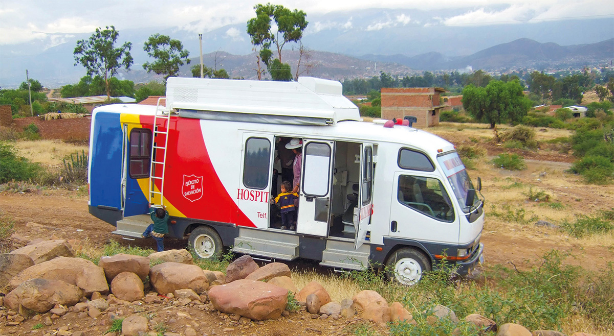 A child looks out from the open door of a mobile clinic