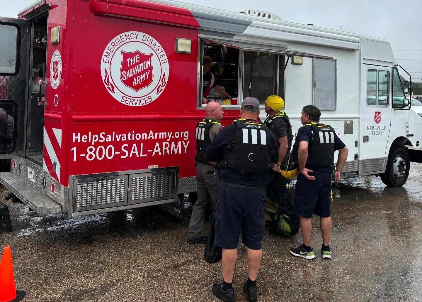People queue in front of a Salvation Army emergency response vehicle