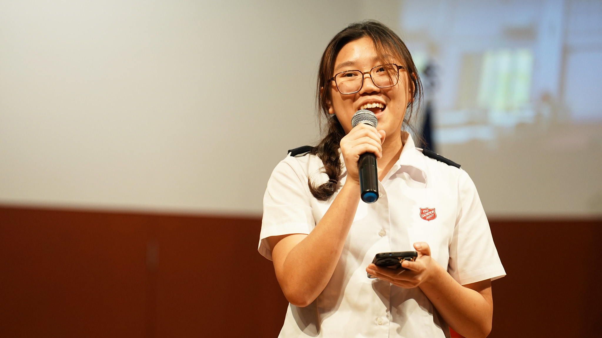 A young Salvationist speaks into a microphone
