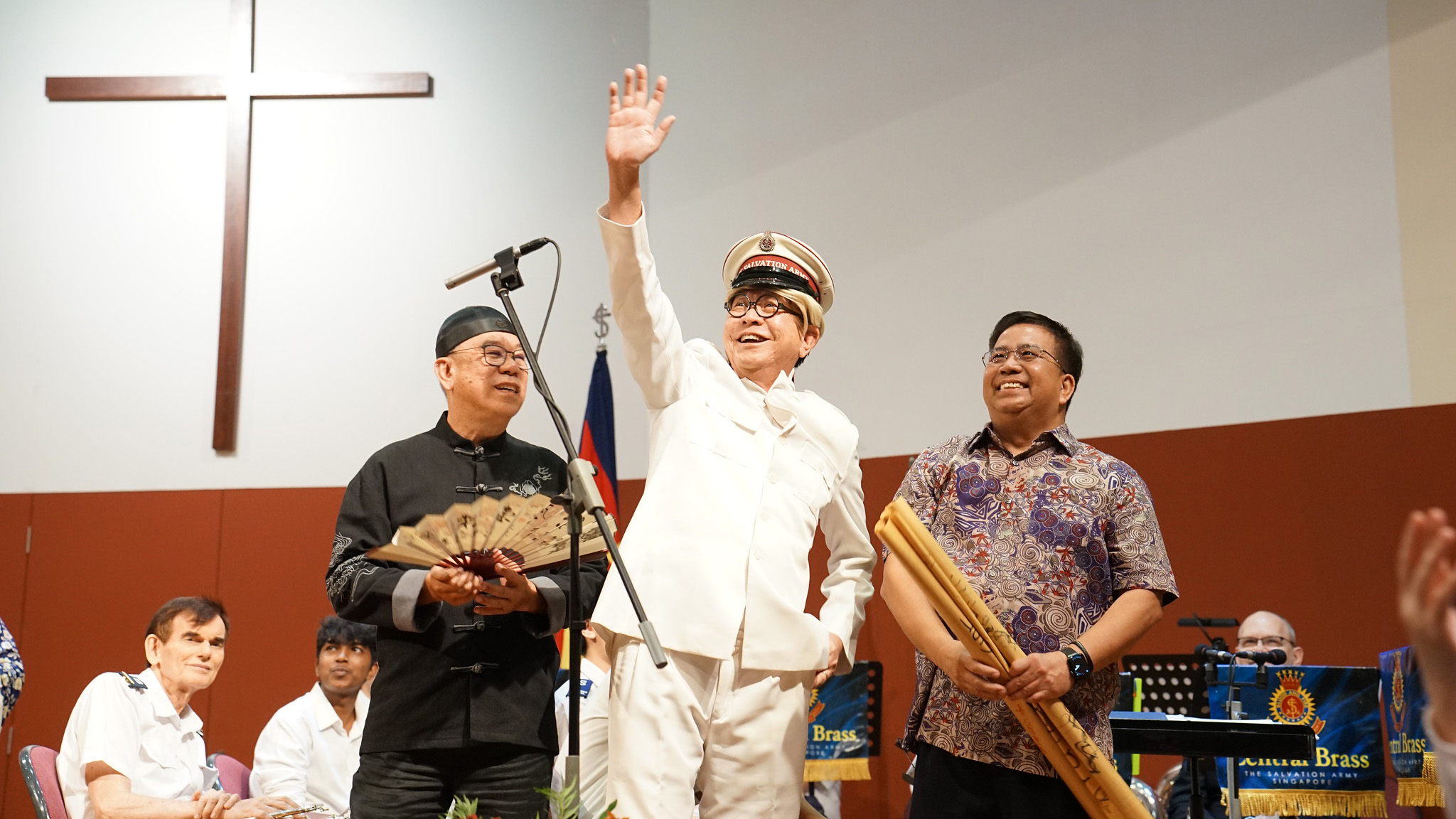 A man in an old-style Salvation Army uniform waves to the congregation