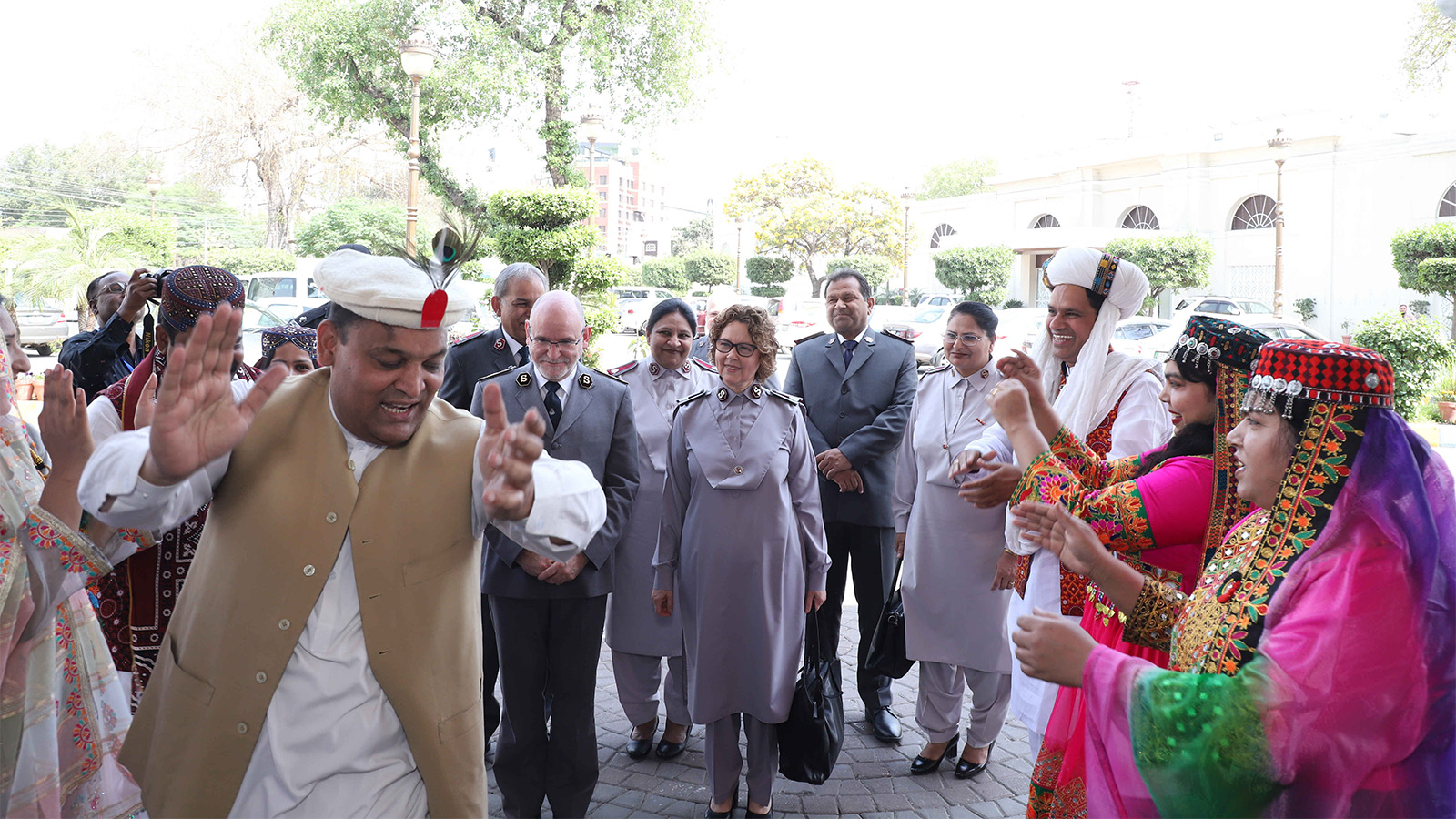 People in traditional dress dance as the international leaders are welcomed to Pakistan