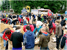 A Salvation Army vehicle offers food and drinks to volunteers who are filling sandbags