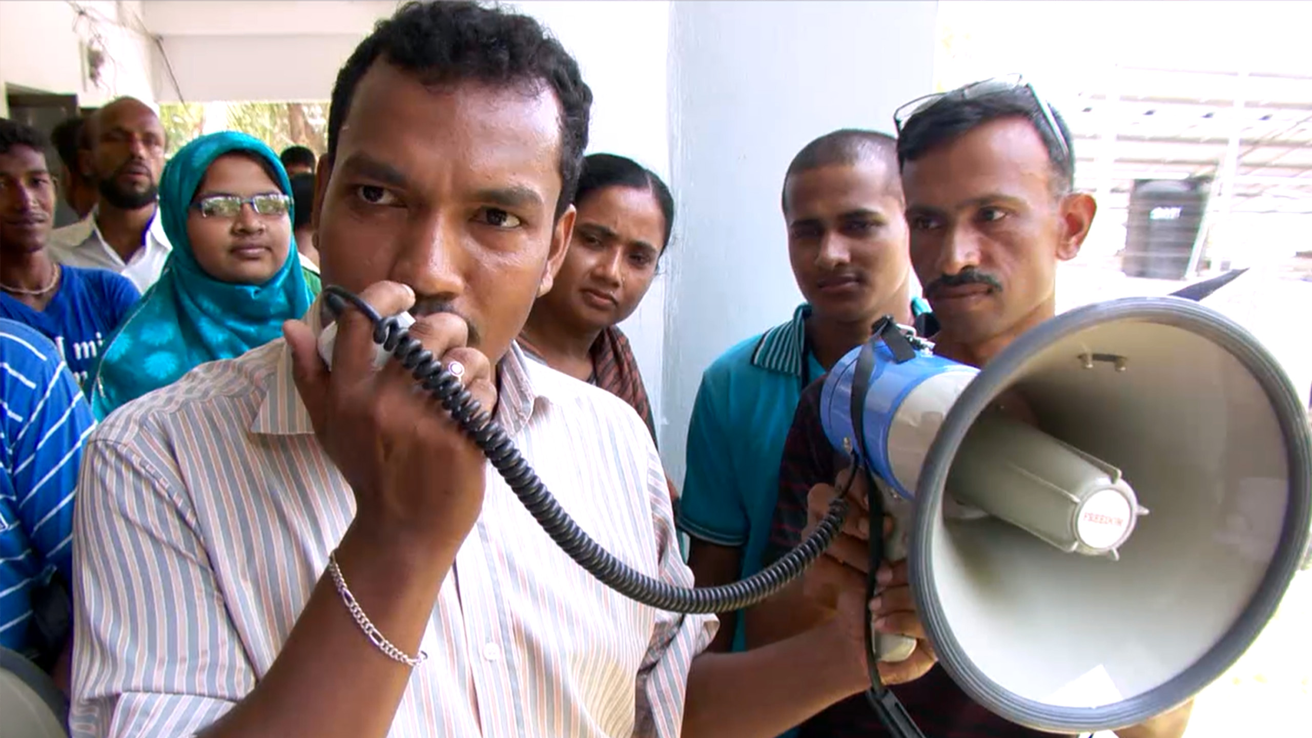 Early warning system, man speaks into megaphone, Bangladesh