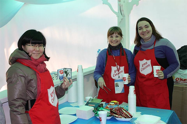 Team members Natasha, Julia and Anastasia serving drinks and offering literature