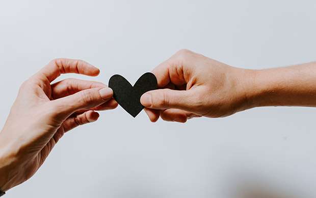 Two hands holding a heart shape