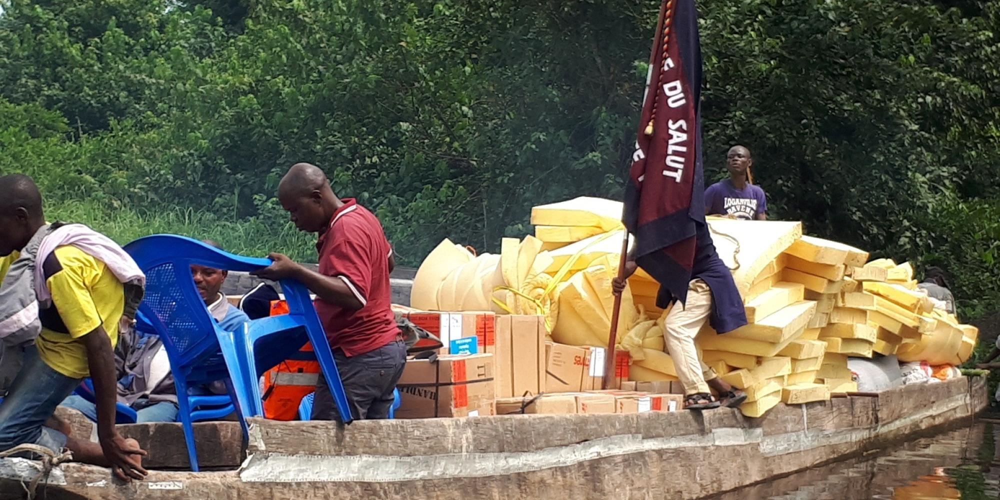 A wooden boat with a Salvation Army flag brings emergency supplies