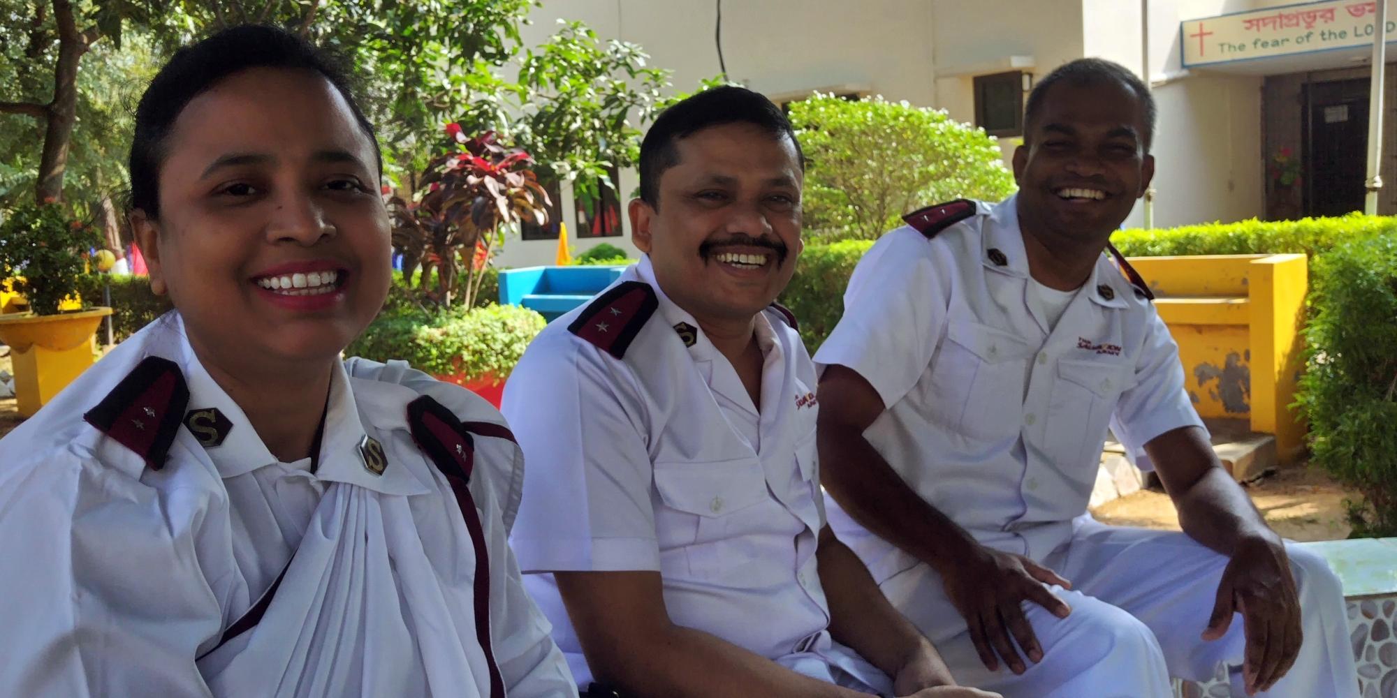 A woman and two men in Salvation Army uniform smile at the camera
