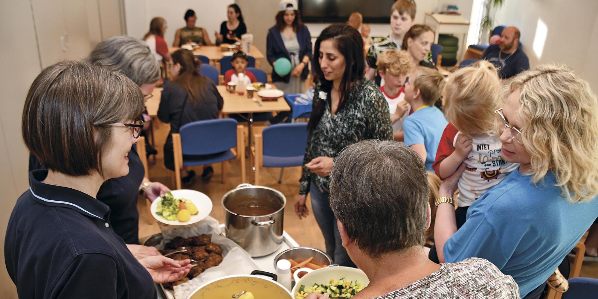 People gather around as food is served