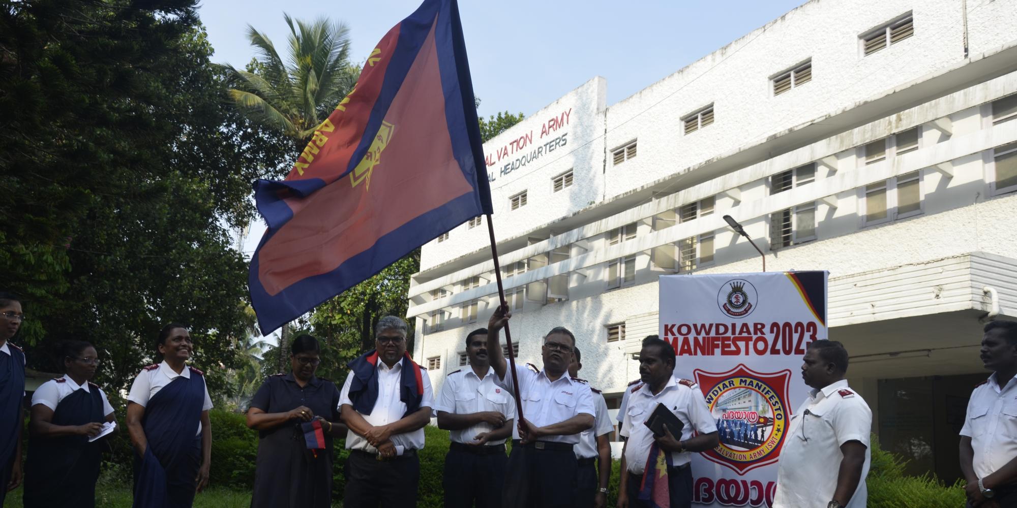 A group of people in Salvation Army uniform holding an Army flag