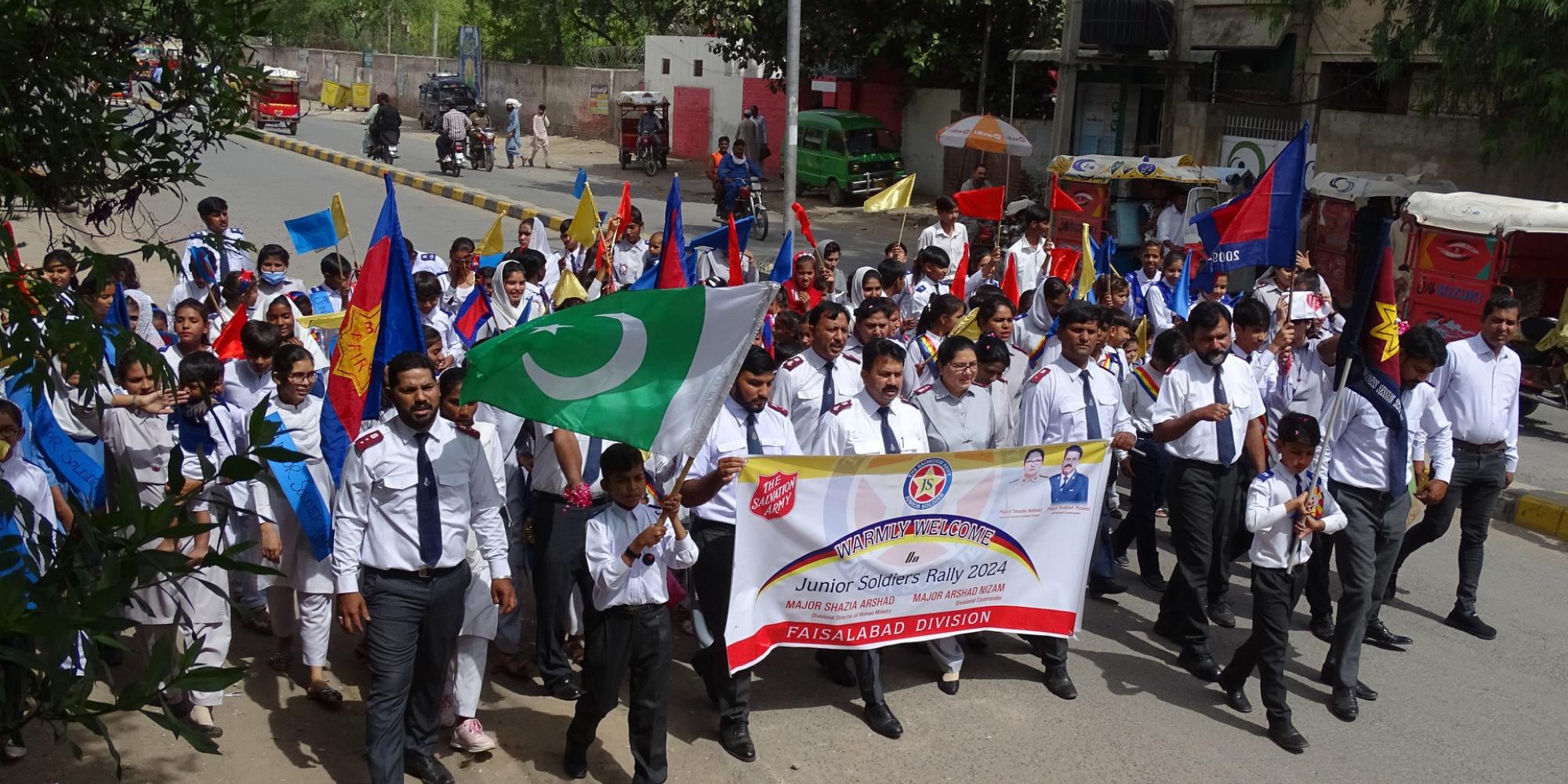 Salvationists march down the street carrying flags