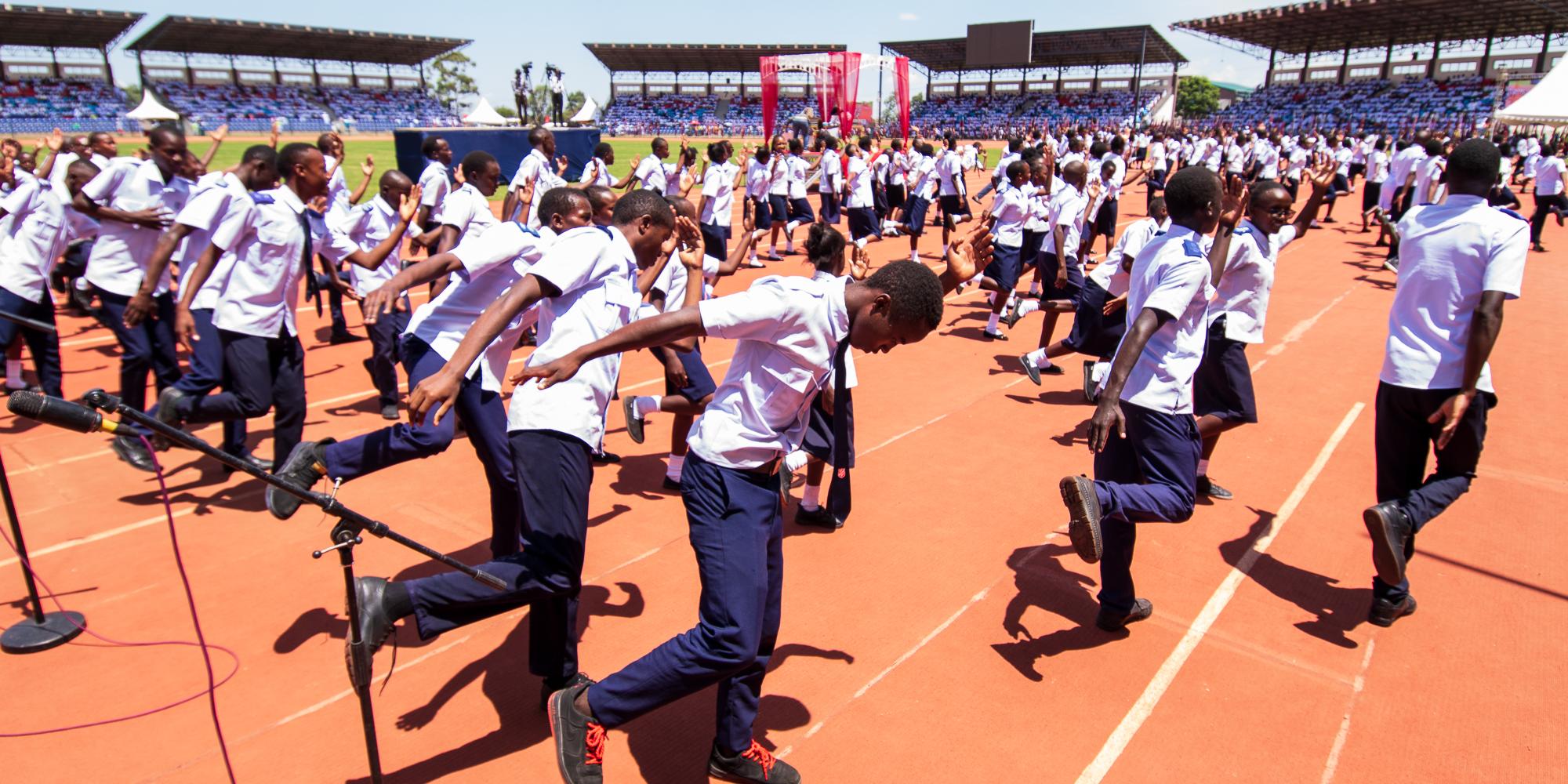 Young people dance in the middle of a stadium
