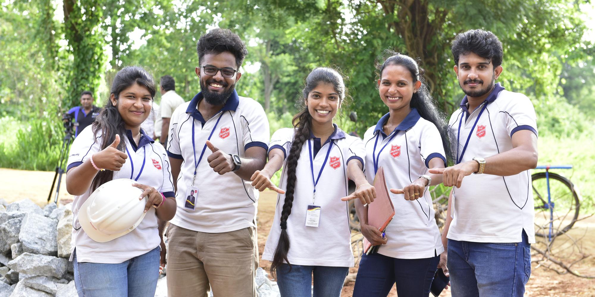 Five people in Salvation Army t-shirts smile at the camera