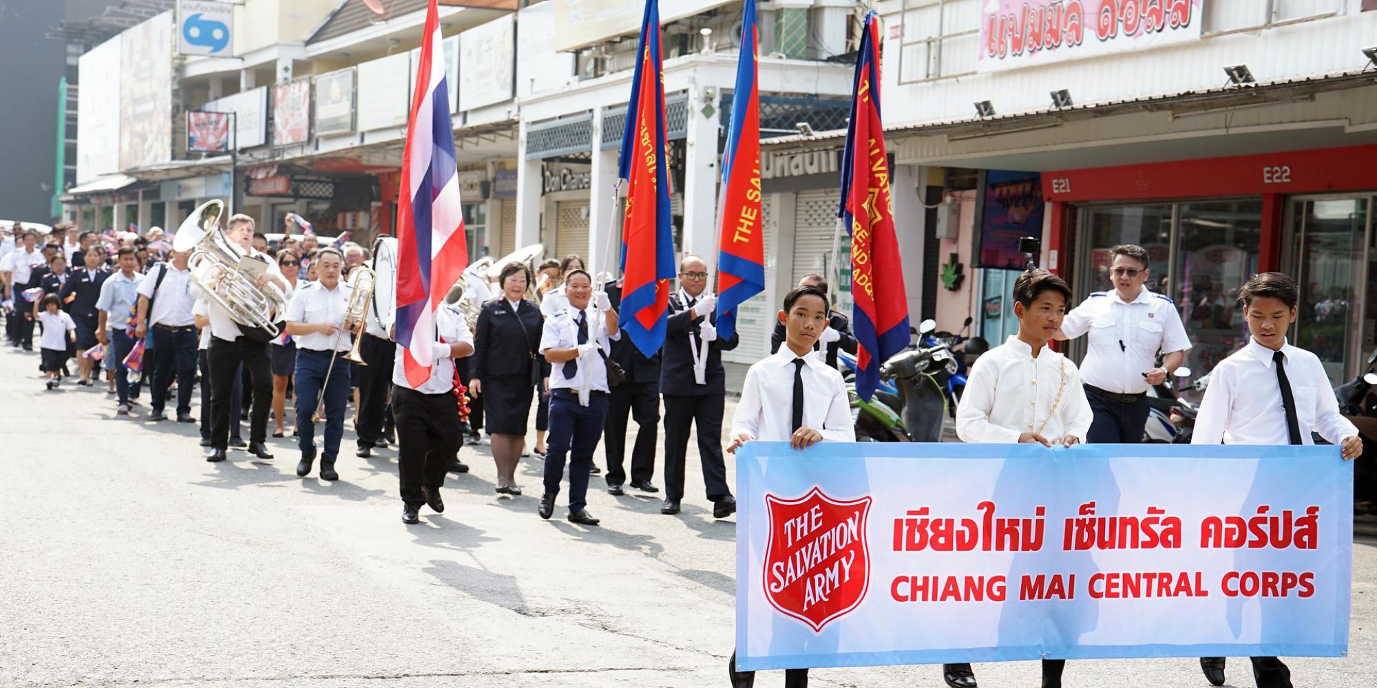Salvationists march down the street with flags