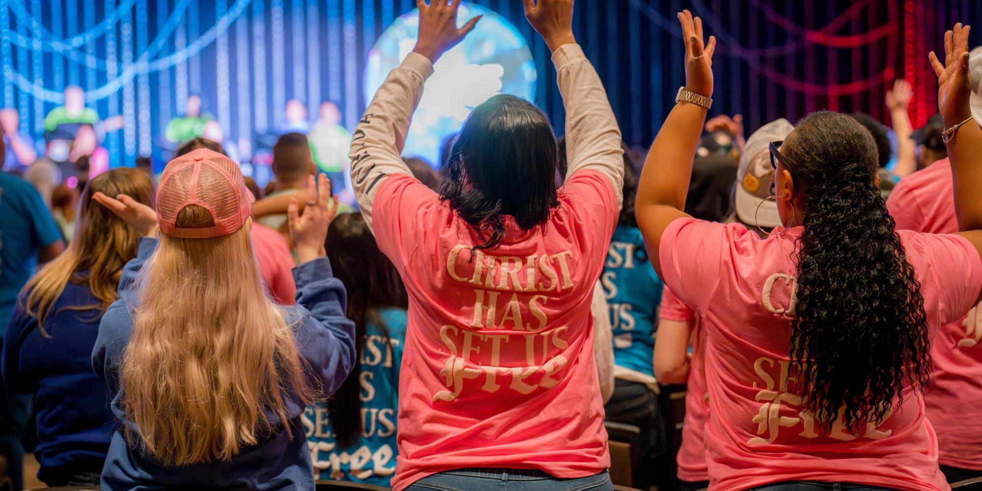 Young people raise their hands in worship