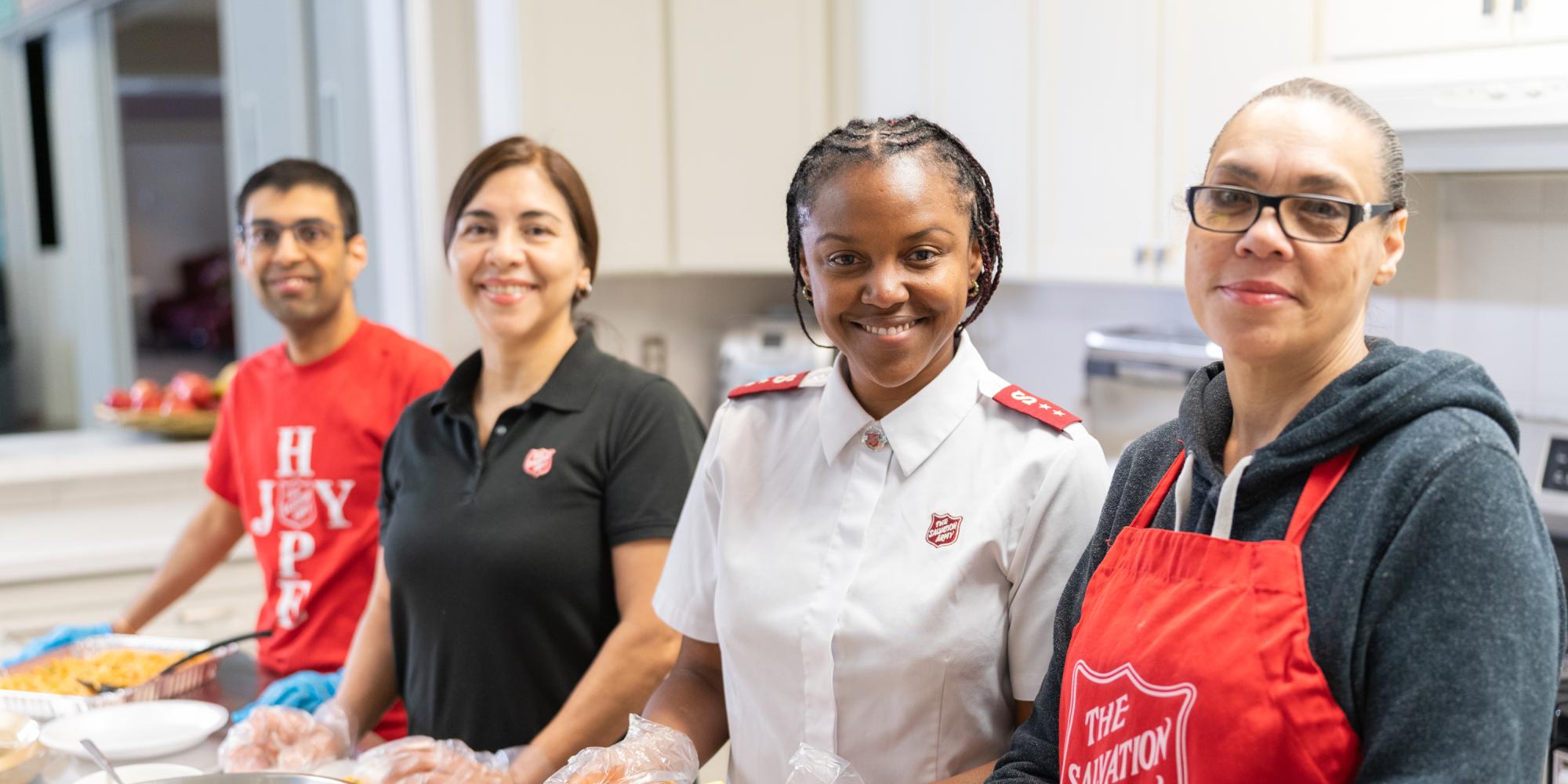A team of four prepare plates of food