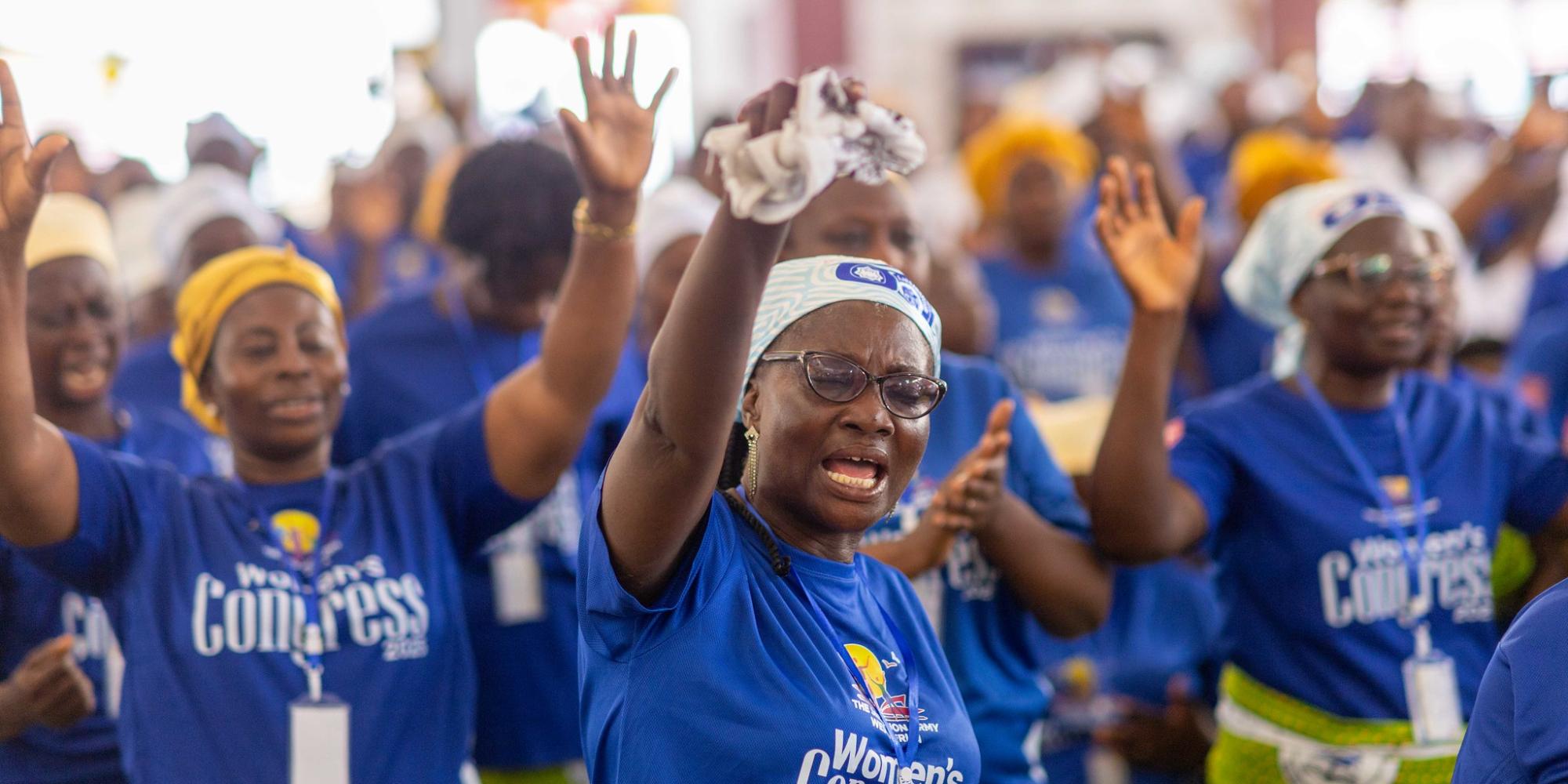 Women raise their hands in worship