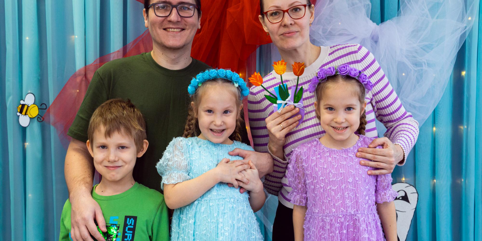 A family of five smile at the camera