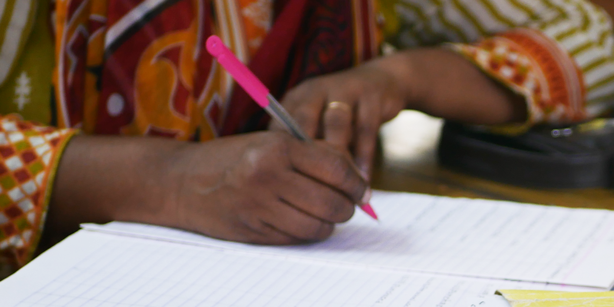 Detail of a woman writing in in a notebook