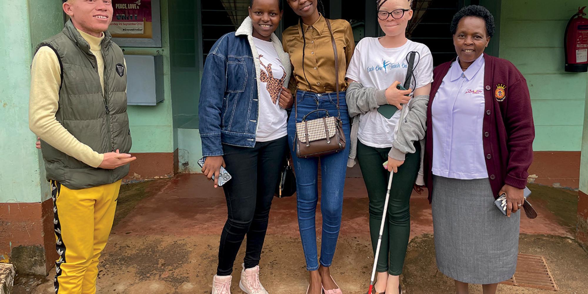 A group of high school students, one holding a mobility cane