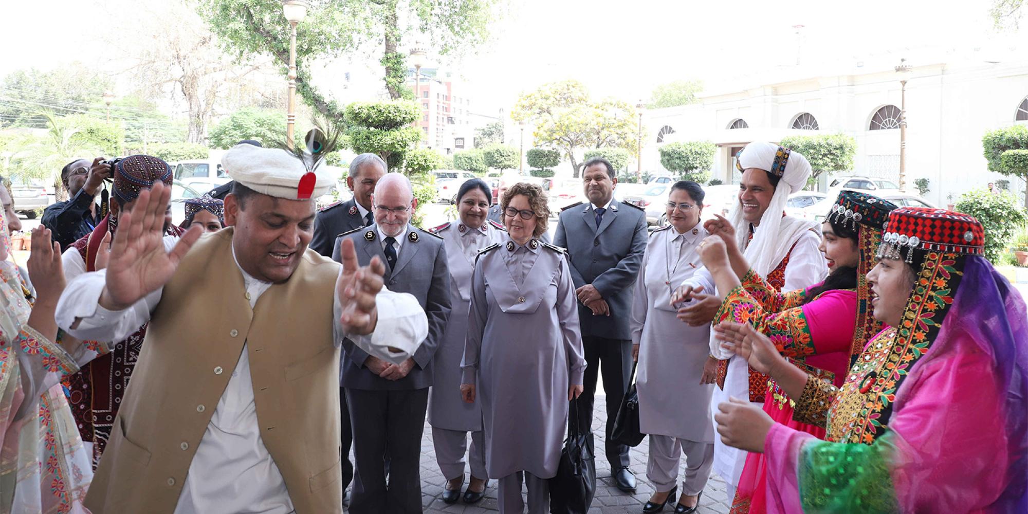 People in traditional dress dance as the international leaders are welcomed to Pakistan