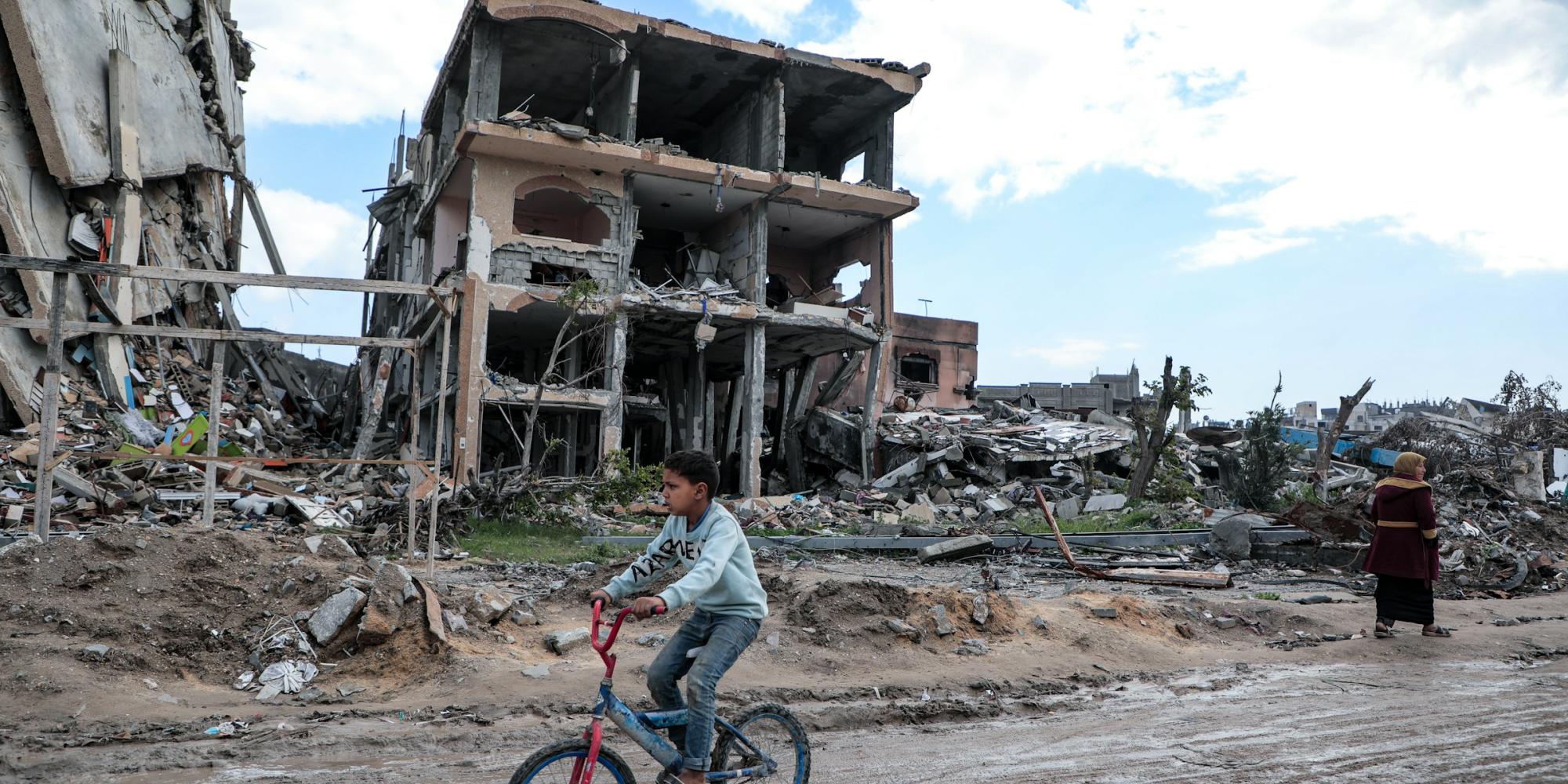 Amid the massive destruction in Jabaliya camp, a child rides his bicycle through the camp's streets.