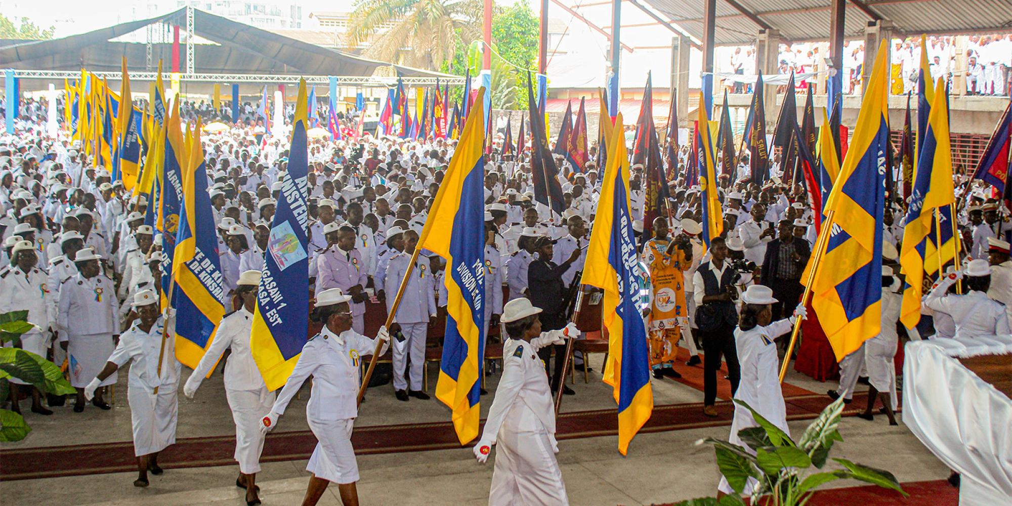 Salvationists march carrying flags