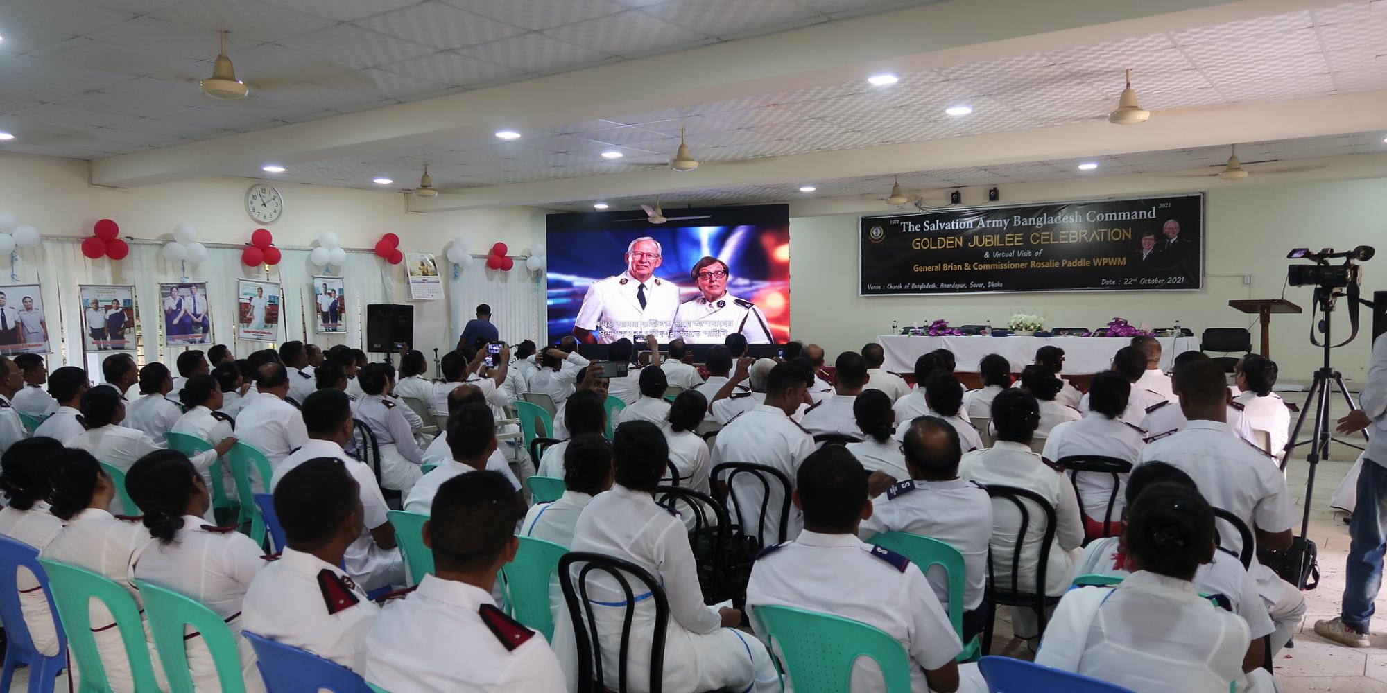 A congregation watch the international leaders on screen