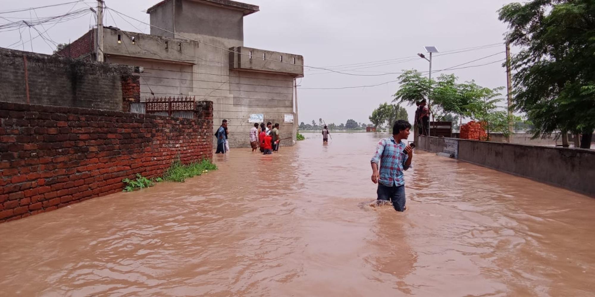 People wade through flood waters