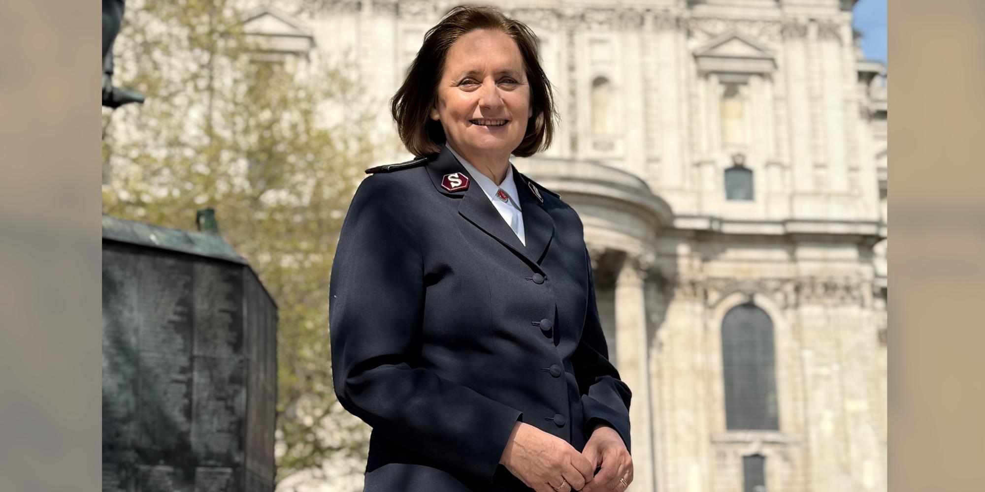 Comissioner Jane Paone stands in front of St Paul's Cathedral on a sunny day. She wears her Salvation Army uniform.