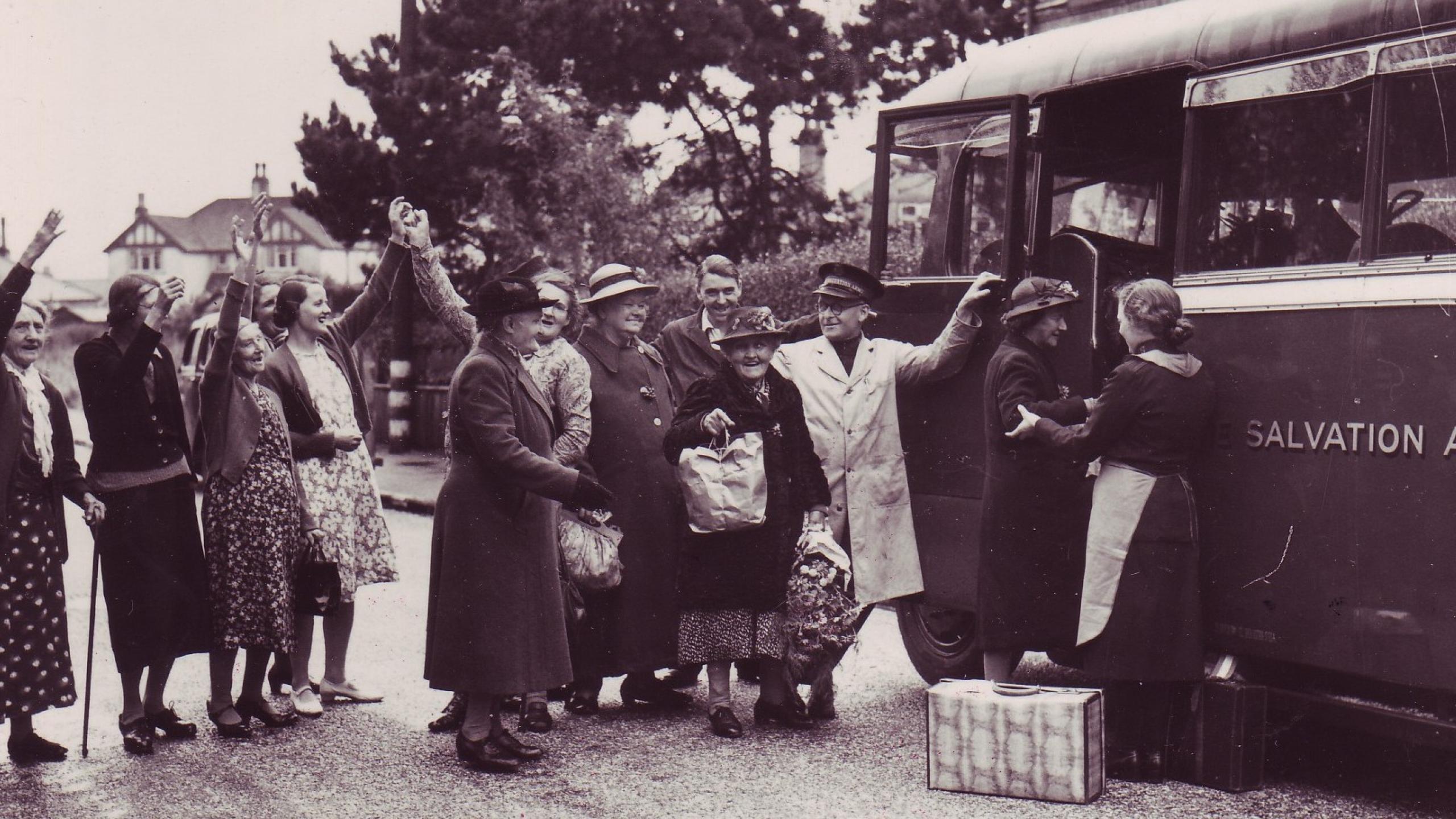 Older women are helped onto a Salvation Army bus