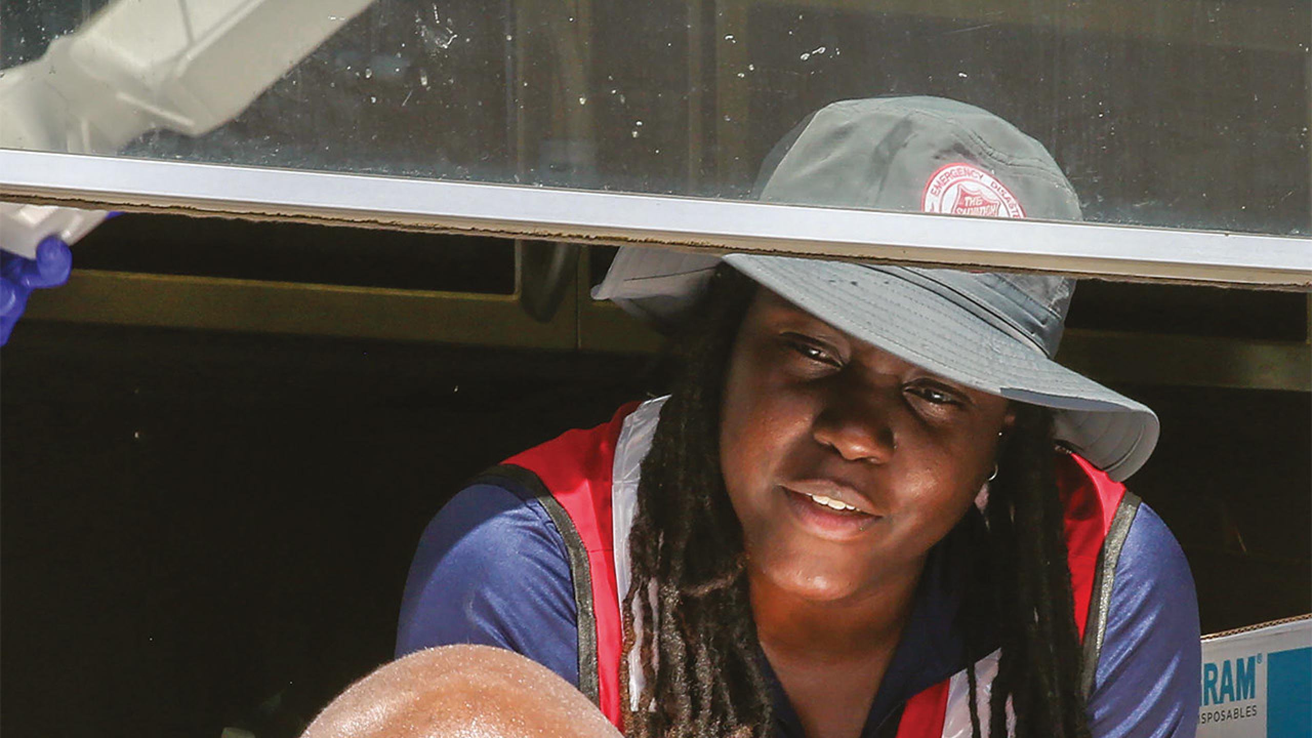A Salvation Army emergency response worker leans out of a truck to speak to someone