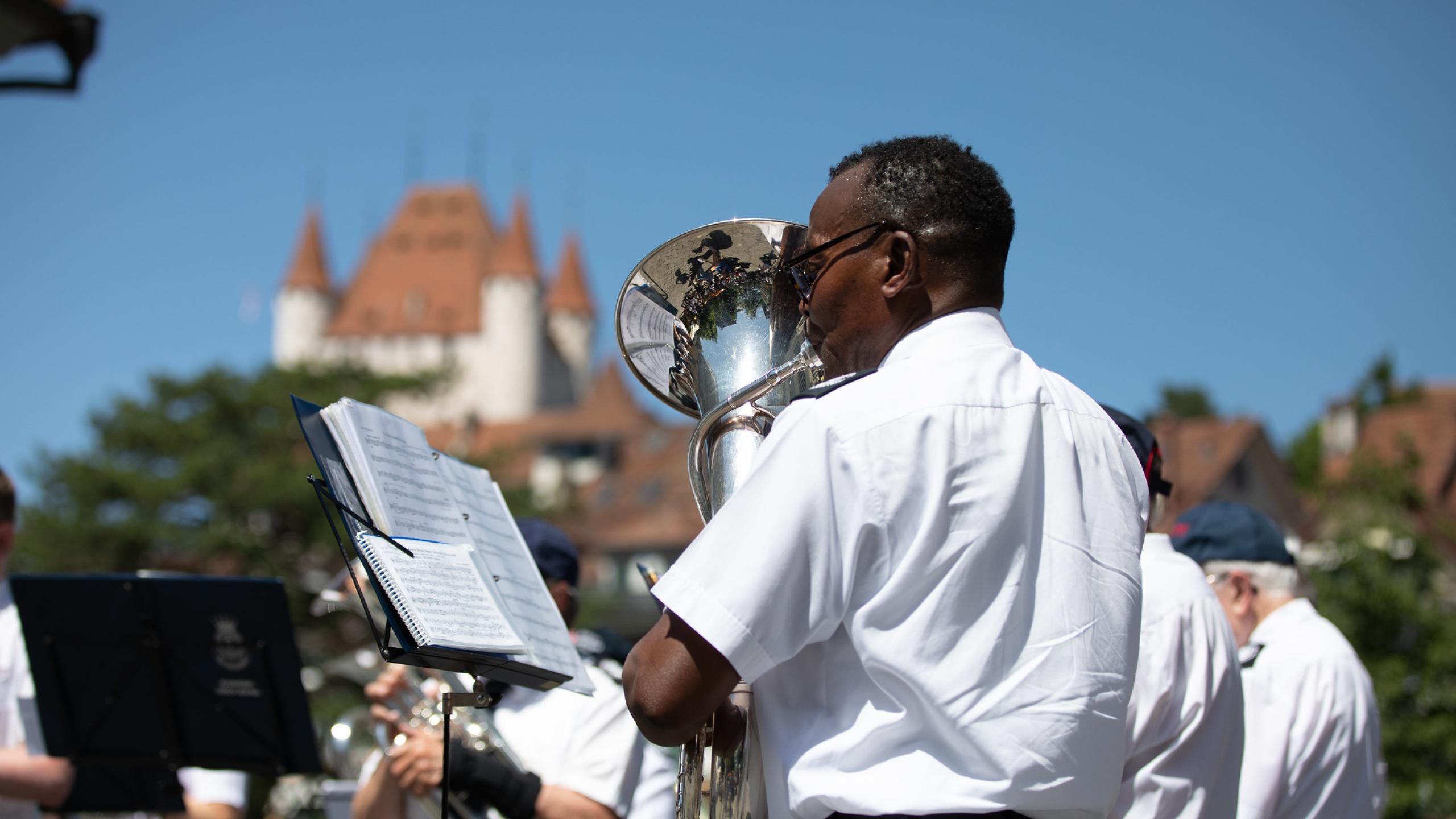A Salvationist plays in a brass band outside