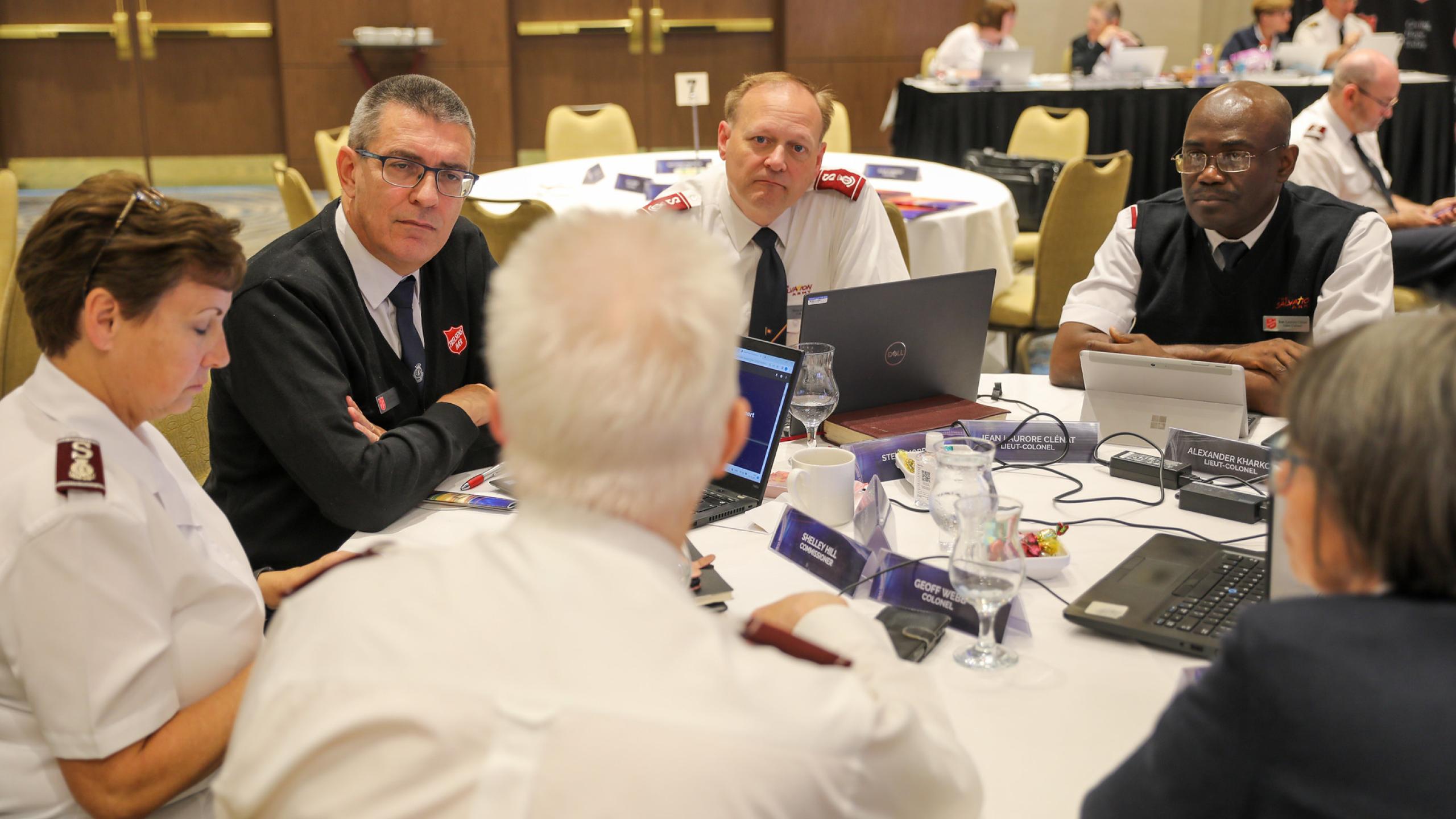 A group of Salvation Army leaders discuss around a table
