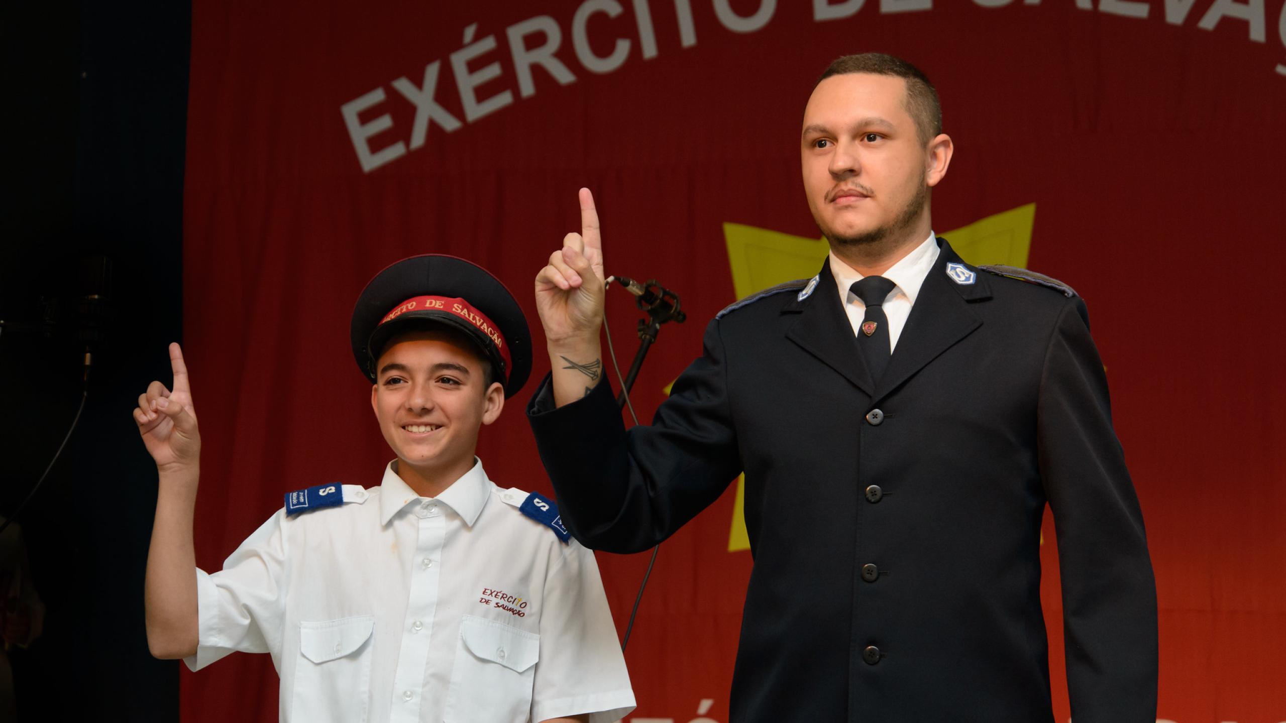 A junior soldier and an officer give the Salvation Army salute