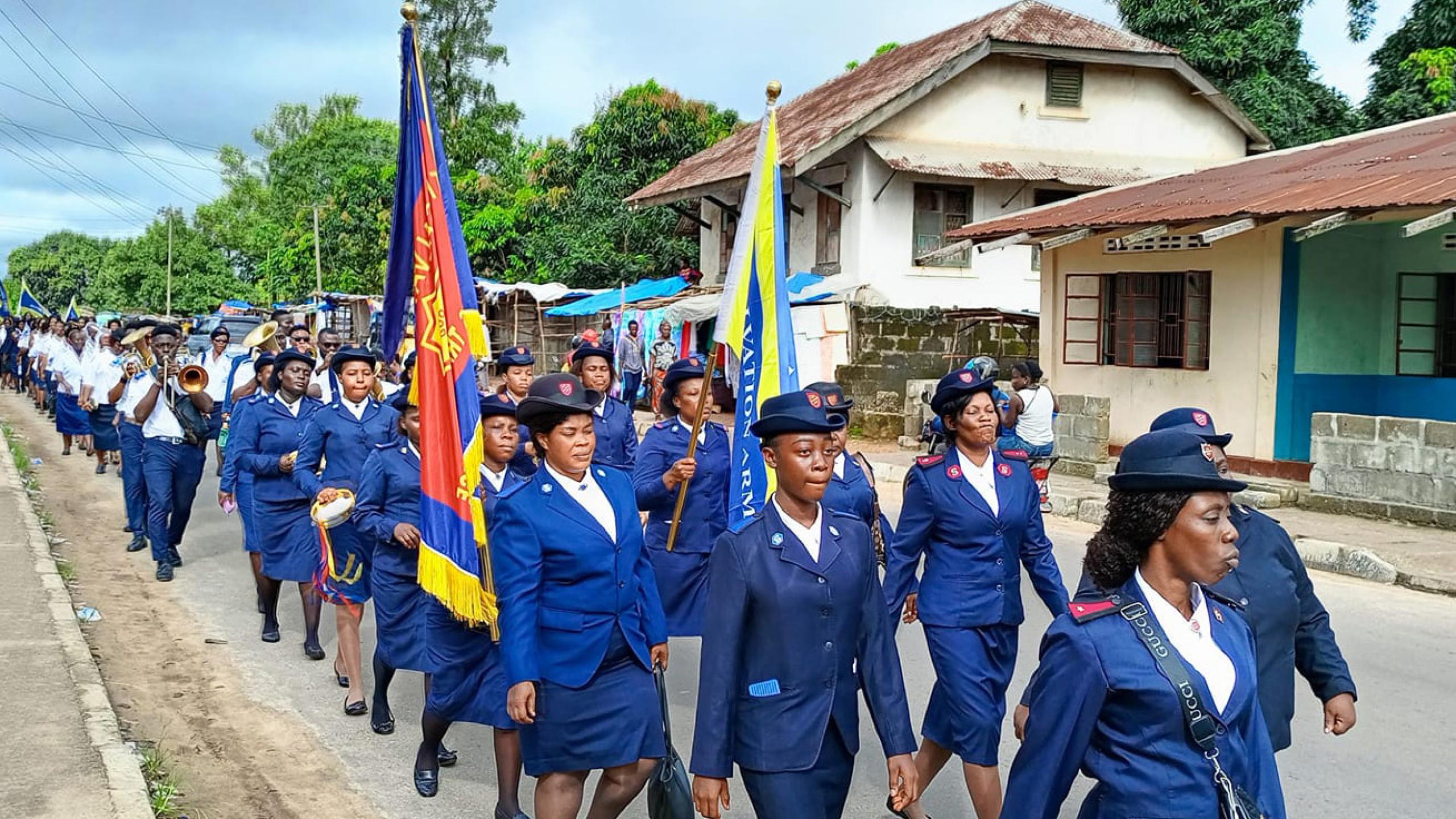 Women in Salvation Army uniforms march down the street