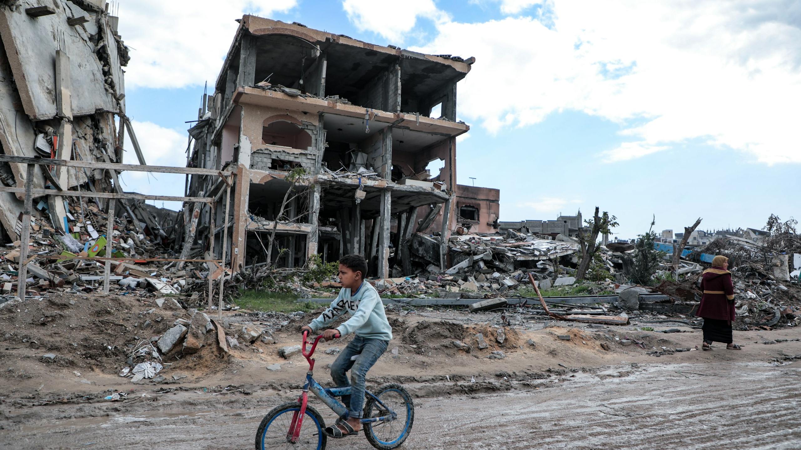 Amid the massive destruction in Jabaliya camp, a child rides his bicycle through the camp's streets.