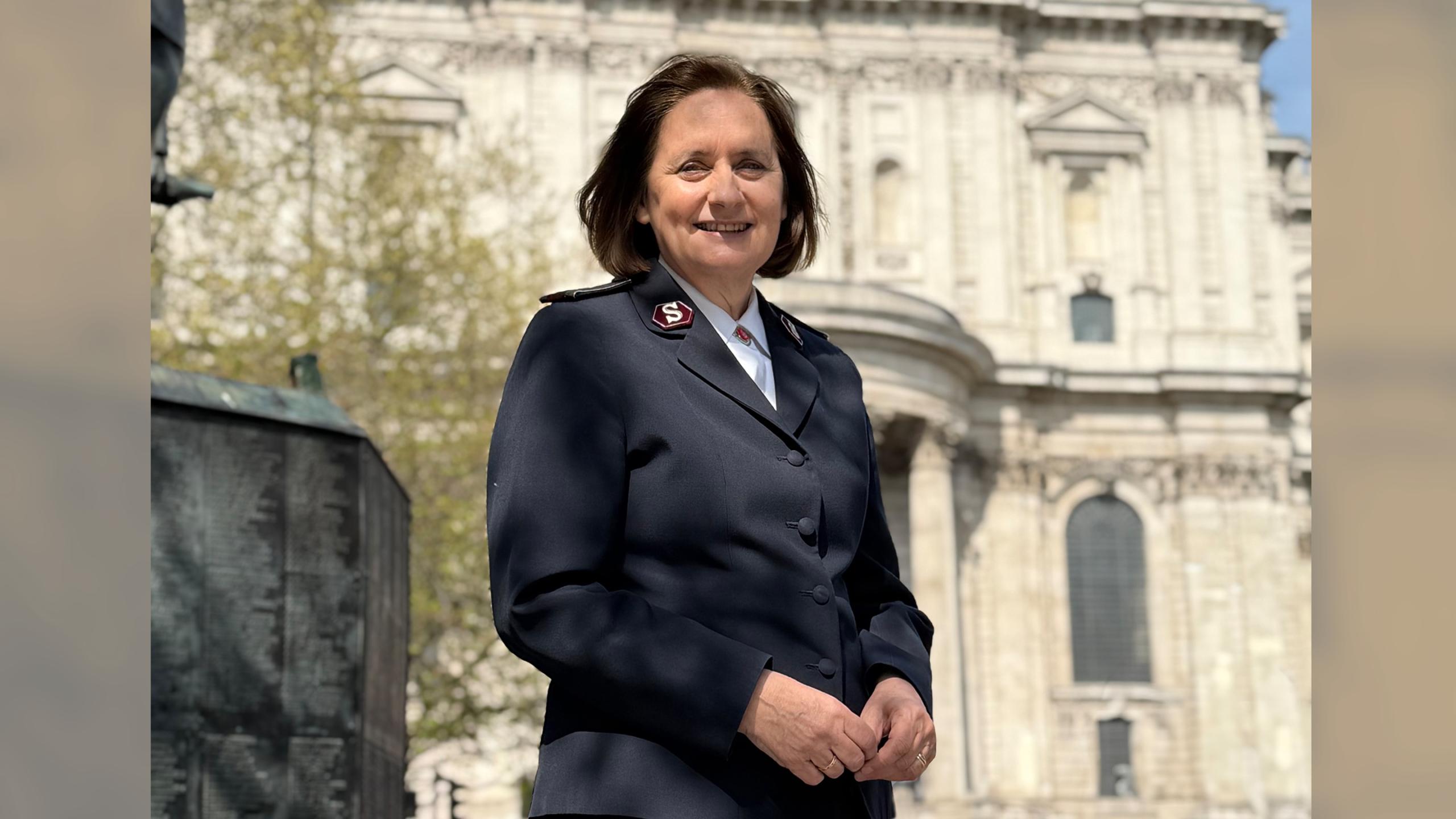 Comissioner Jane Paone stands in front of St Paul's Cathedral on a sunny day. She wears her Salvation Army uniform.