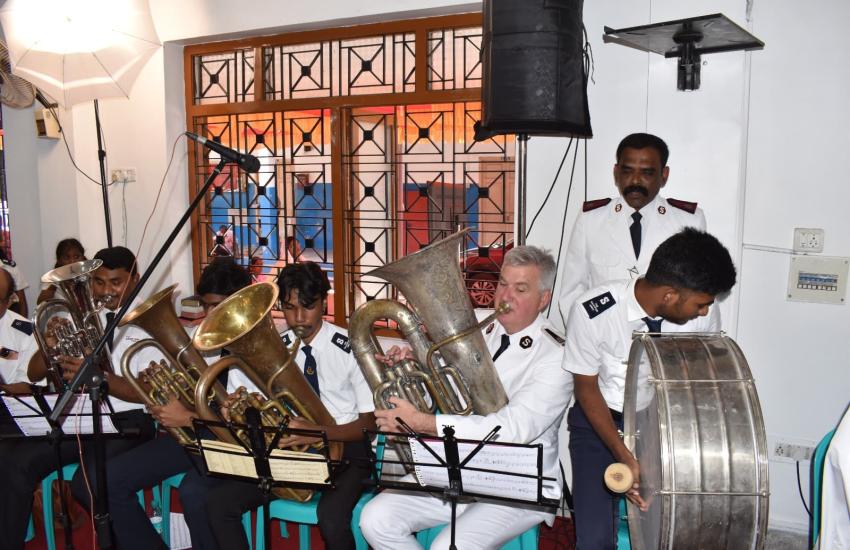 The Chief of the Staff plays the tuba alongside members of the corps playing brass instruments and a drum