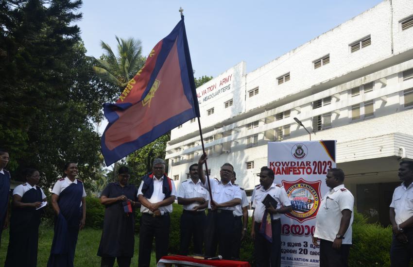 A group of people in Salvation Army uniform holding an Army flag