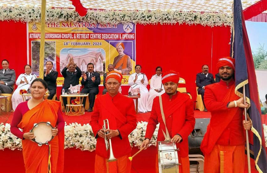A group wearing red hold a timbrel, a trumpet, a drum and a Salvation Army flag