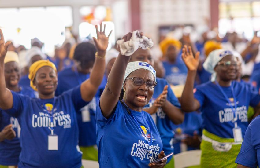Women raise their hands in worship