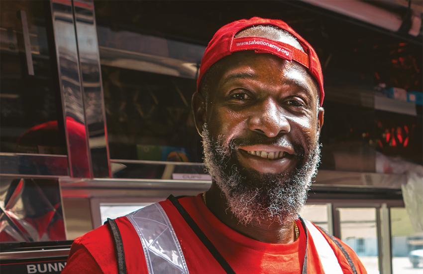 A Salvation Army emergency response worker holds a boxed meal ready to distribute
