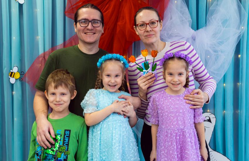 A family of five smile at the camera