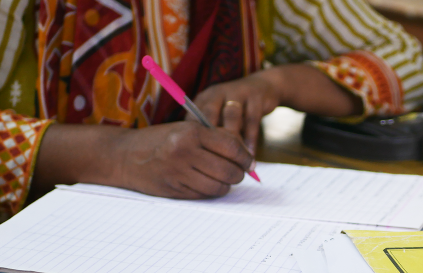 Detail of a woman writing in in a notebook
