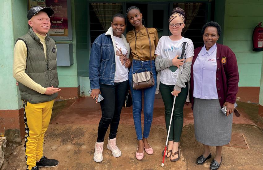 A group of high school students, one holding a mobility cane