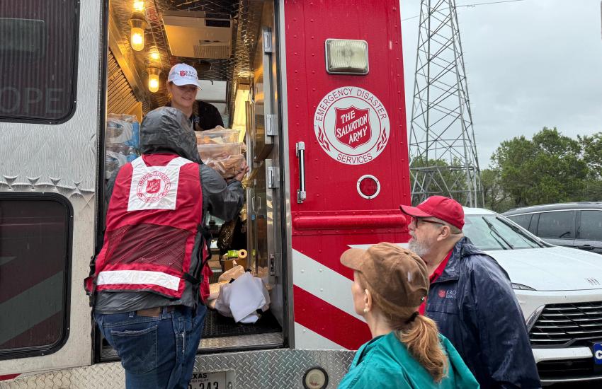 Volunteers unload supplies from a Salvation Army emergency vehicle