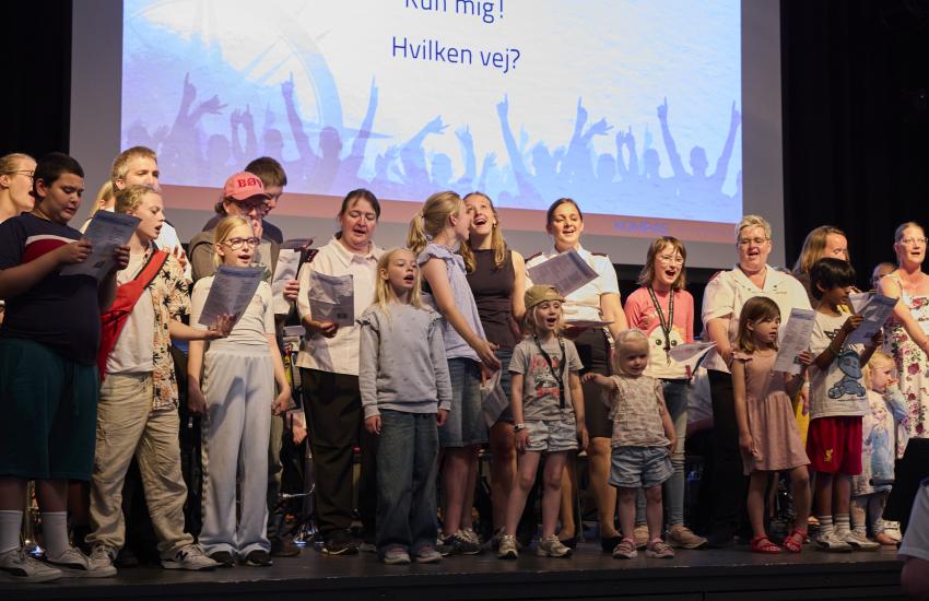 Adults and children sing in a family choir